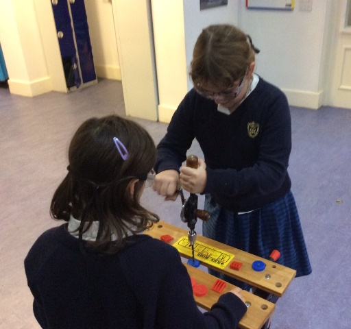 Year 5 pupils using hack saw to cut wood